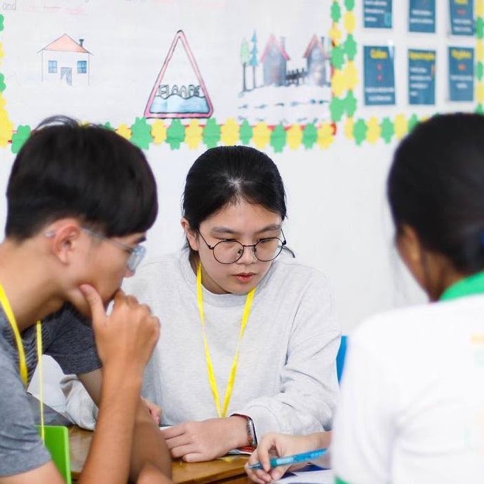 Students working on their debate skills around a classroom table
